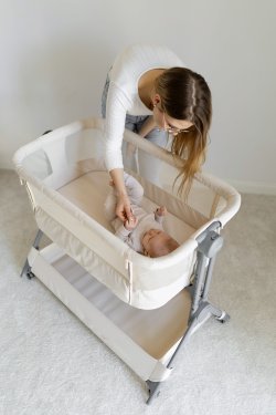 mama-nachyla-się -nad-łóżeczkiem-w-którym-leży-dziecko